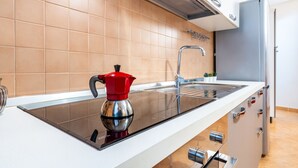 A modern kitchen with a stovetop, sink, and stainless steel appliances. - Vico 1° Sulis Apartment 3 with Wi-Fi and Air Conditioning (Cagliari)