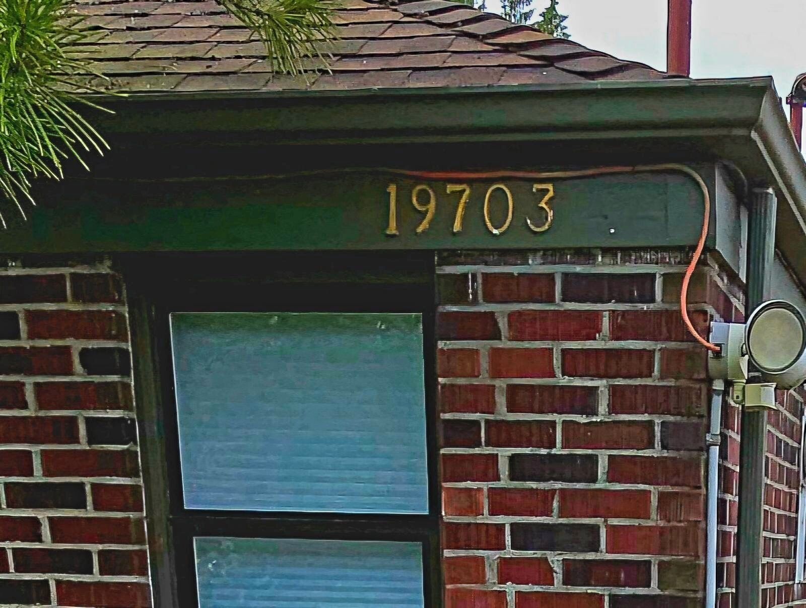 A brick building with the number 19703 on the facade.