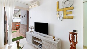 A modern living room with a flat-screen TV, a marble fireplace, and a large 'LOVE' sign on the wall. - Vacation Apartment 'Aloe Puerto Rico Beach' with Sea View, Wi-Fi and Air Conditioning (Puertorico -Mogan)