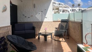 A covered outdoor seating area with a sofa, chairs, and a table. - Vacation Apartment 'Aloe Puerto Rico Beach' with Sea View, Wi-Fi and Air Conditioning (Puertorico -Mogan)