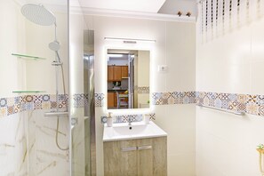 A bathroom with a shower, sink, and mirror. - Vacation Apartment 'Aloe Puerto Rico Beach' with Sea View, Wi-Fi and Air Conditioning (Puertorico -Mogan)