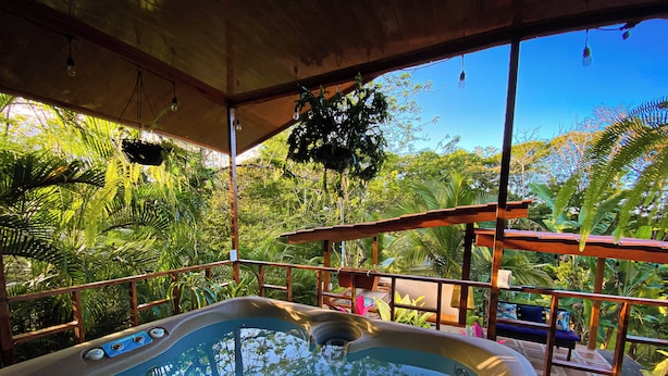 Un bain à remous avec vue sur une végétation luxuriante et une terrasse en bois.