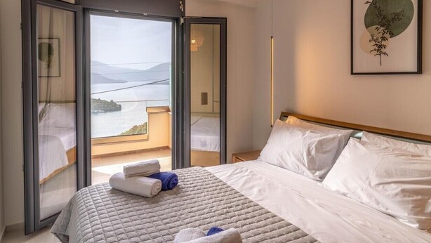 Una habitación de hotel con una cama, vistas al mar y un balcón.