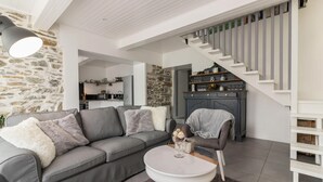 A modern living room with a grey sofa, a coffee table, and a staircase leading to a loft area. - Cottage 'Gîte De Pène Blanque' with Mountain View, Private Terrace and Wi-Fi (Arbas)