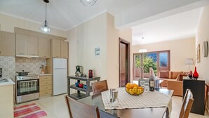 Une cuisine moderne avec un coin repas, un réfrigérateur, une cuisinière et une machine à café.