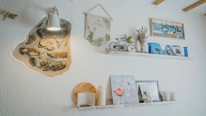 A room with a stone wall, a hanging light fixture, a bicycle, and various decorative items on shelves.