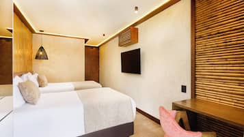 Habitación de hotel moderna con una cama grande, un escritorio, un televisor y un panel de pared de madera.