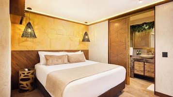 Un dormitorio moderno con una cama grande, dos lámparas colgantes, un cabecero de madera, una mesita de noche y un baño con lavamanos y espejo.
