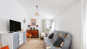 A living room with a TV, sofa, and a cabinet.