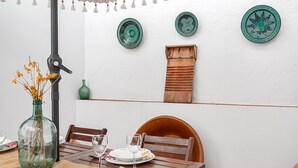Une table à manger, avec des chaises, des assiettes et des verres, préparée pour un repas.