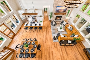 A spacious open-plan living area with a kitchen, dining space, and seating area. - Swim Spa & Game-Loaded Family Cabin | Sleeps 14 (Broken Bow)