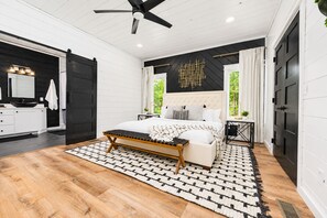 Una camera da letto con un letto, un comodino e una ventola a soffitto.