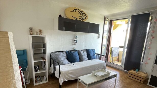 A living room with a sofa, a coffee table, and a bookshelf.