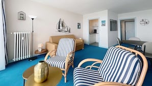A living room with a sofa, chairs, a radiator, a lamp, and a wall art piece. - QUIBERON - Studio - 38m² - Sea view (QUIBERON)