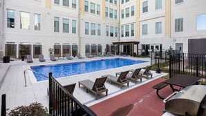 A hotel with a swimming pool, lounge chairs, and a covered seating area. - Spacious Downtown Apartment | Pool + In-Unit laundry (Dallas)