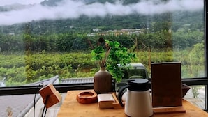 A table with a vase, a kettle, a wooden box, and a cup. - Zuisusheng Guesthouse (Xi'an)