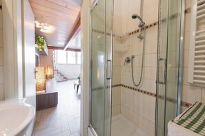 Chuveiro, secador de cabelo, toalhas de banho, shampoo