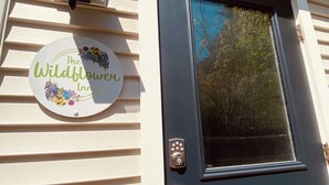 A door with a keypad lock and a sign above it that reads "The Wildflower Inn". - Stunning seaside studio, walk to beach, romantic getaway for 2  (Plymouth)