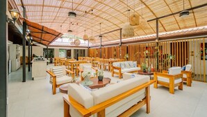 Un interior espacioso y bien iluminado con techo alto, mobiliario de madera y una zona de estar central.