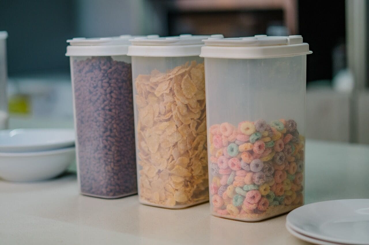 Tres recipientes con tapas, cada uno lleno de distintos tipos de cereal.