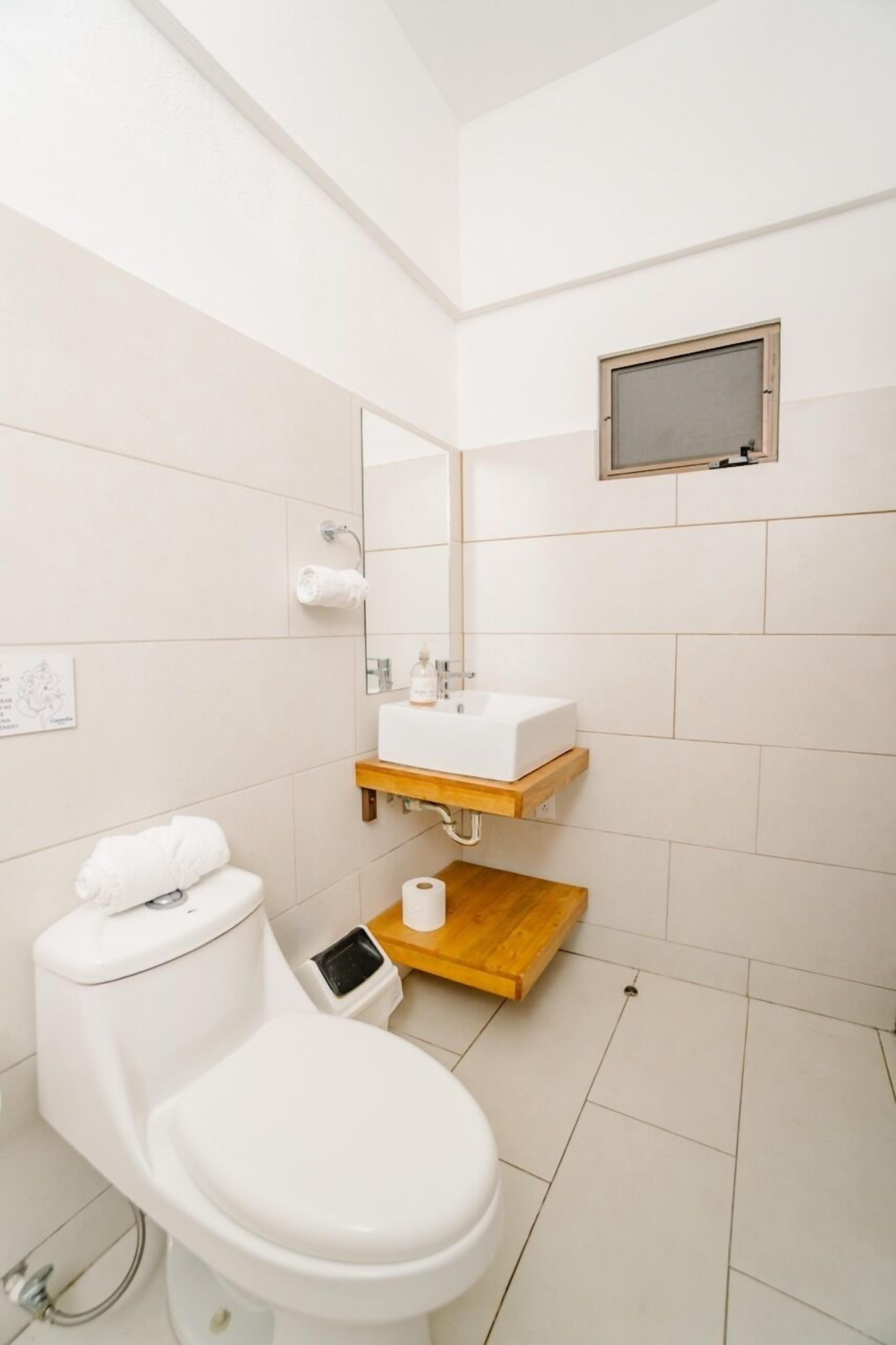 Une salle de bain moderne équipée de toilettes, d’un lavabo et d’une douche.
