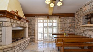 A stone fireplace with a bench and table in a room with stone walls and a wooden ceiling. - House 2326/110968 (Istria - Vodnjan), 5000m from the beach (Vodnjan)