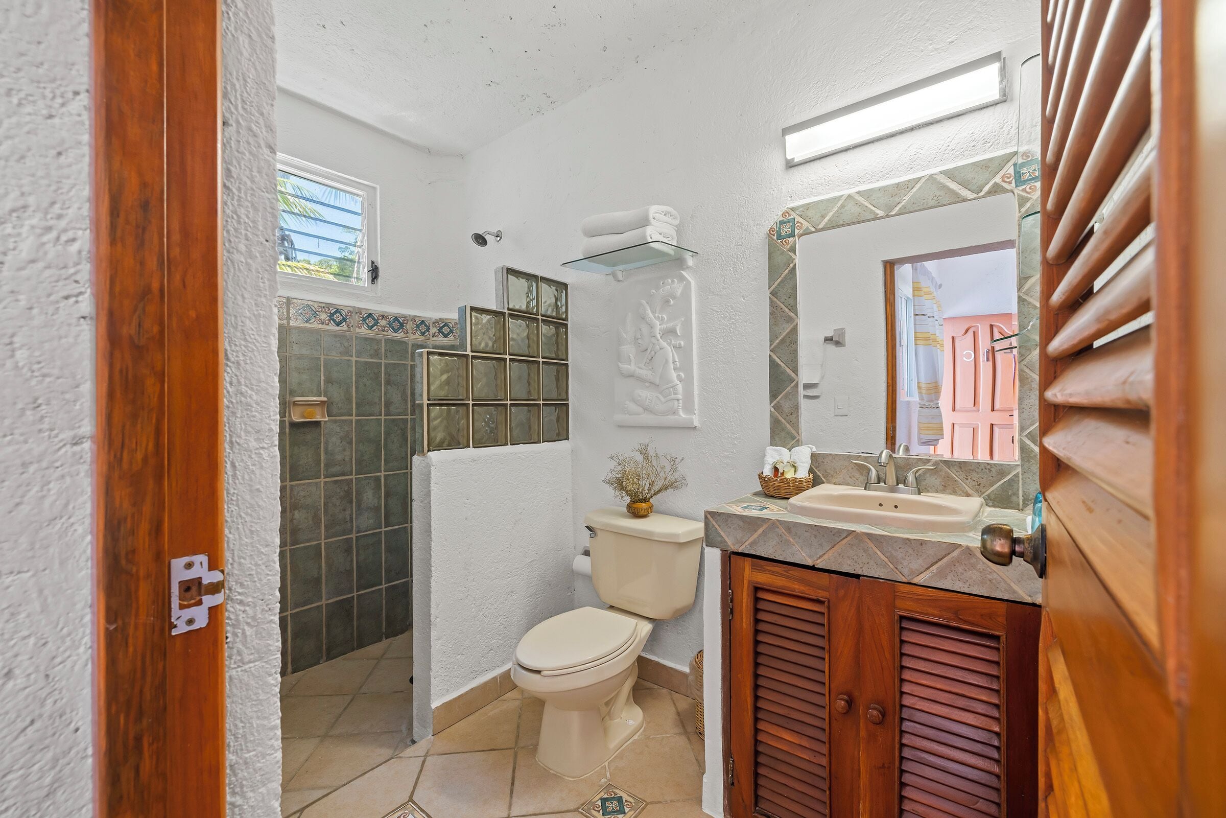 A bathroom with a toilet, sink, and shower area.