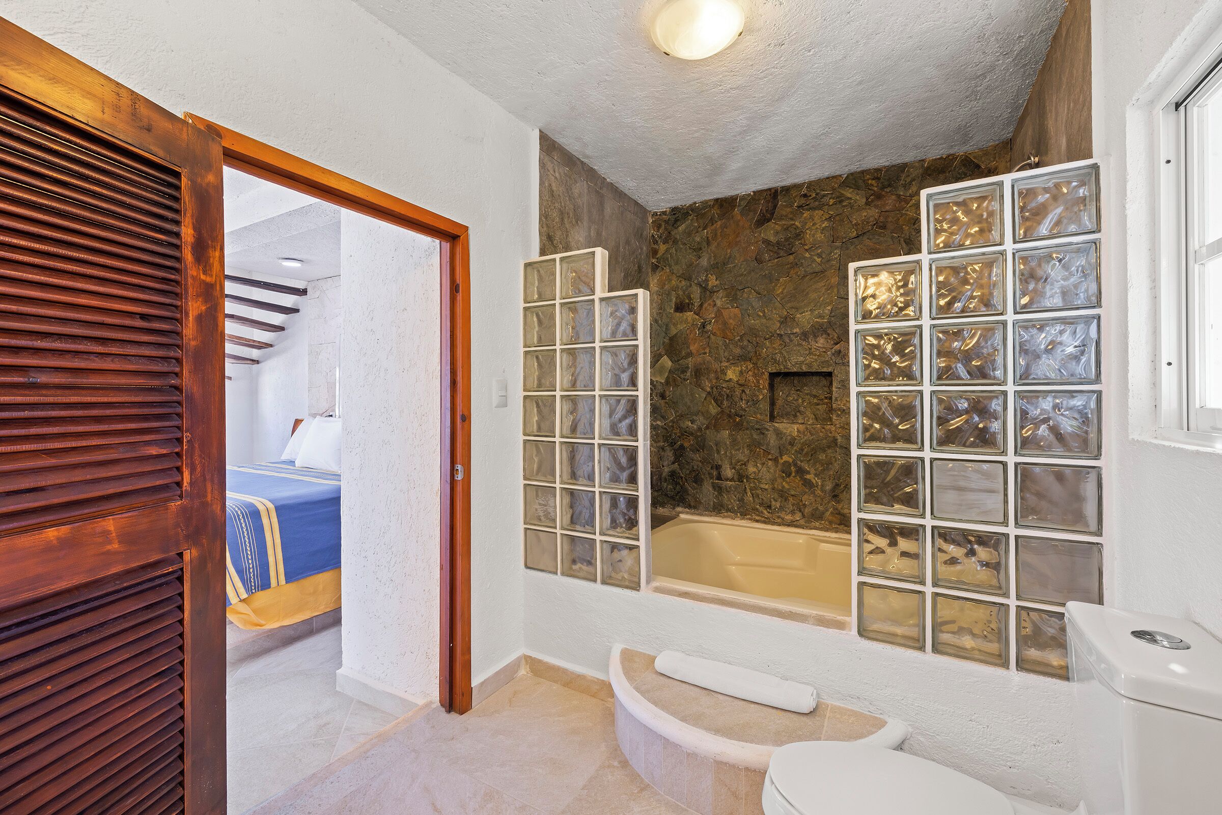 A bathroom with a bathtub, a toilet, and a shower area.
