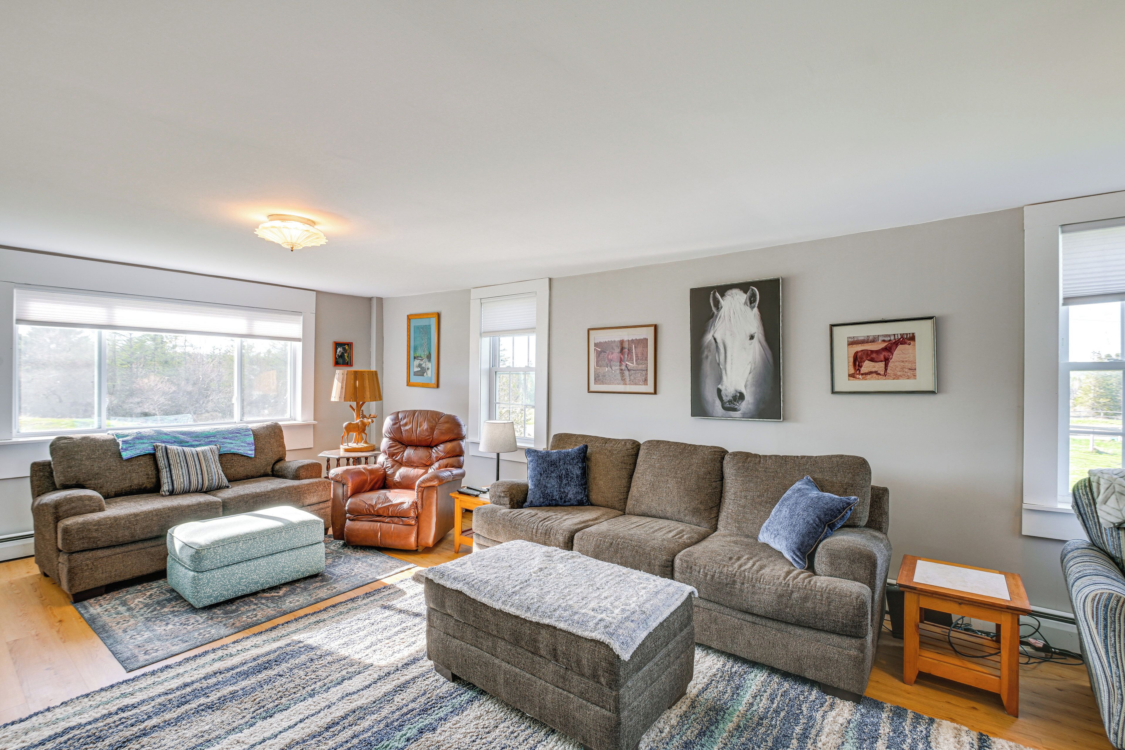 A spacious living room with a large window, a fireplace, and a comfortable seating area.