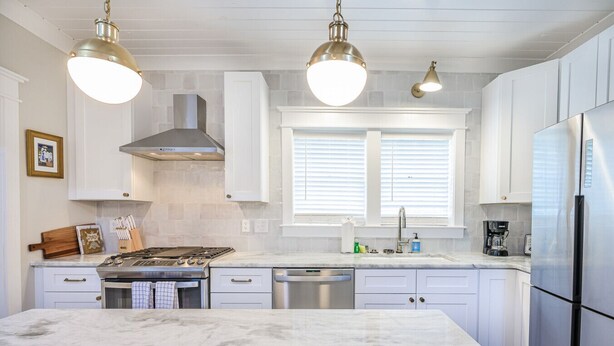 A modern kitchen with white cabinetry, a marble island, stainless steel appliances, and pendant lighting. - The Bogard Only 4 Blocks to King! Unit A (Charleston)