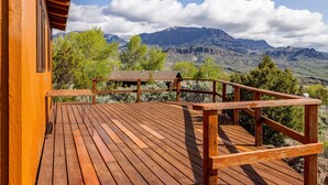A wooden deck with a view of mountains and trees. - Loren's Lookout- pet friendly, on the way to Yellowstone National Park (Cody)