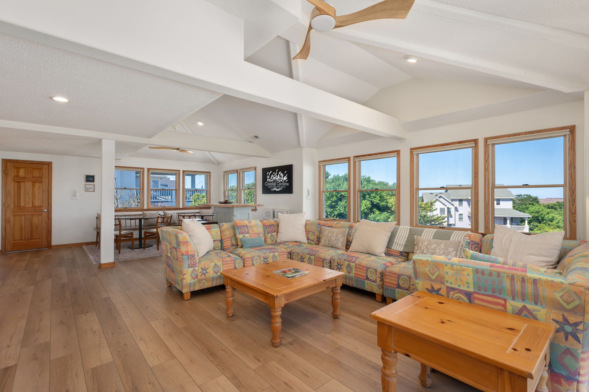 A spacious living room with a large sofa set, wooden coffee table, and a view of the outdoors.