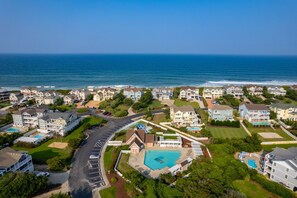 Una zona residencial costera con casas, una piscina y una carretera.
