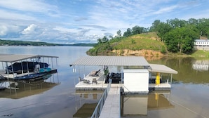 Un muelle con una zona de estar techada y un bote.