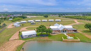 Een ruim aanzienlijk resort met meerdere witte gebouwen, een centraal paviljoen en een waterpartij.