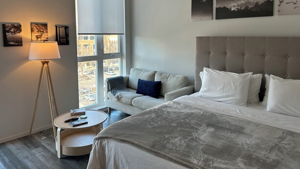 A bedroom with a bed, a sofa, a round table, and a floor lamp. - Stylish Midtown of Sacramento Luxurious and Spacious Studio at level 6 nice view (Sacramento)