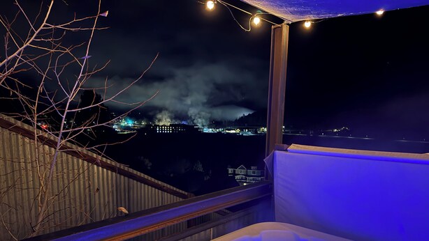 Un bain à remous avec vue sur le paysage urbain illuminé la nuit.