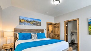 Une chambre à coucher avec un lit, une table de chevet, une tête de lit en bois et un tableau accroché au mur.