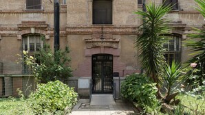 A building with a central entrance, a sign reading "SCALA", and a small window above the door. - Testaccio 11 - FromHometoRome (Roma)