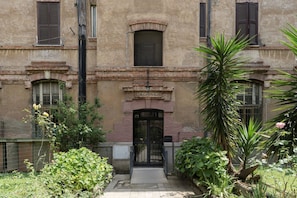 A building with a central entrance, a sign reading "SCALA", and a small window above the door. - Testaccio 11 - FromHometoRome (Roma)