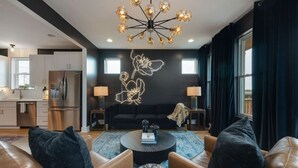 A modern living room with leather sofas, a round coffee table, and a unique light fixture.