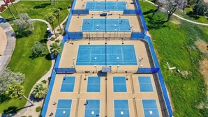 A multi-level tennis court complex with multiple courts, surrounded by greenery and a parking area. - Private Pool & Hot Tub | Indian Palms 3BR (Indio)