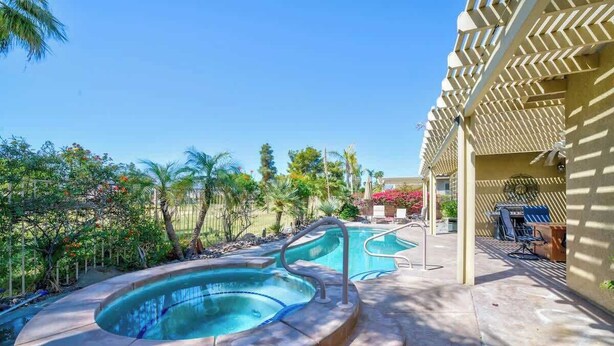 A pool area with a hot tub and lounge chairs, surrounded by palm trees and a pergola. - Private Pool & Hot Tub | Indian Palms 3BR (Indio)