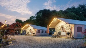 Two tents with attached awnings, a gravel ground, and a forested backdrop. - Gapyeong Sanmaeul Glamping (Gapyeong)