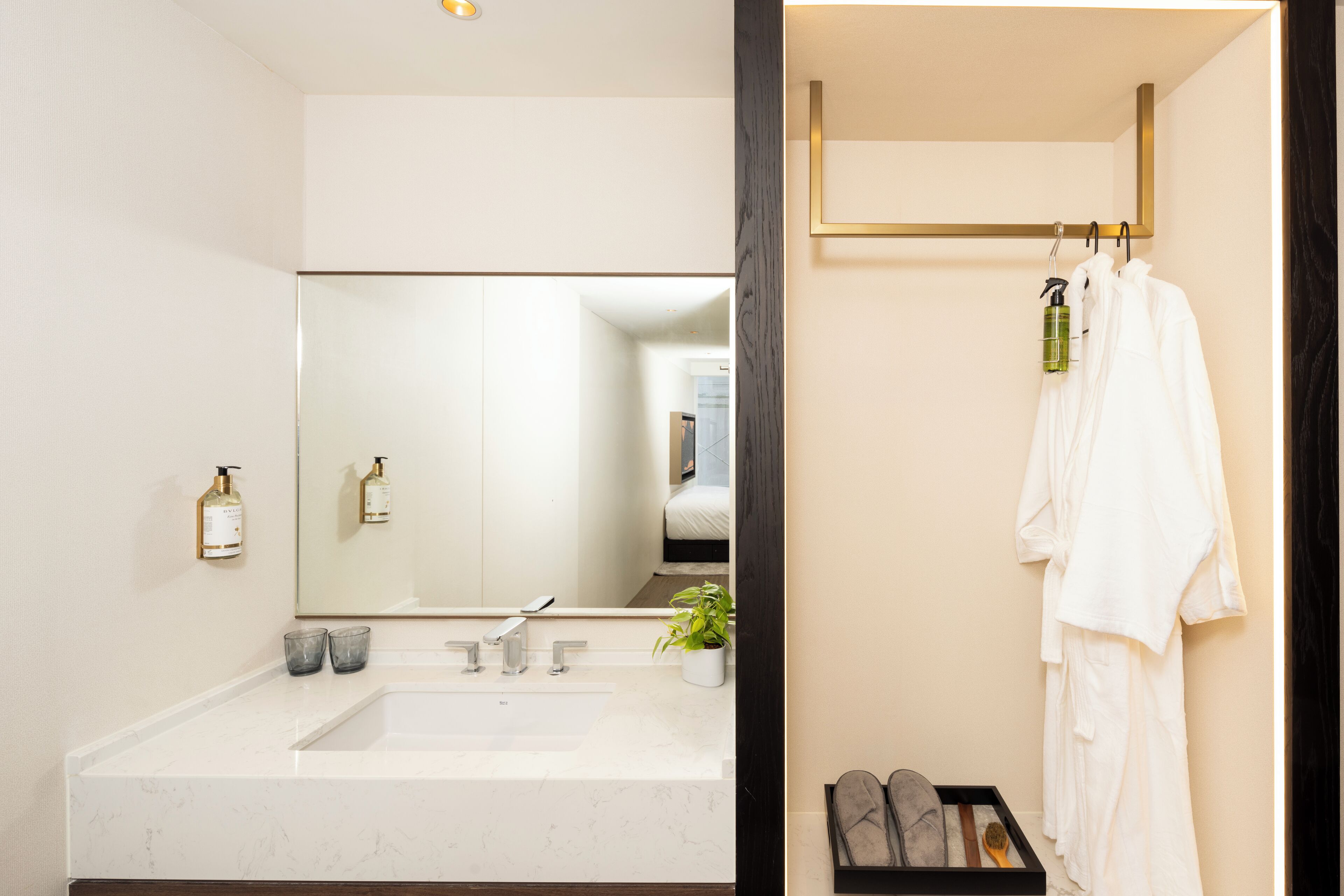 A bathroom with a large mirror, a sink, and a towel rack.