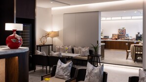 Una sala moderna con un conjunto de sofás, una mesa de comedor y una zona de cocina al fondo.