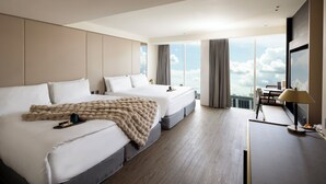 Habitación de hotel moderna con una cama grande, un escritorio y vistas a la ciudad.