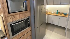 Een keuken met houten kastjes, een roestvrijstalen koelkast en een ingebouwde oven.