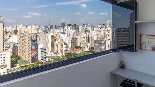 A room with a large window overlooking a cityscape. - Ycp2307 in S o Paulo (São Paulo)