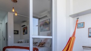 A bedroom with a bed, a hammock, and a sliding glass door leading to another room. - Ycp2307 in S o Paulo (São Paulo)
